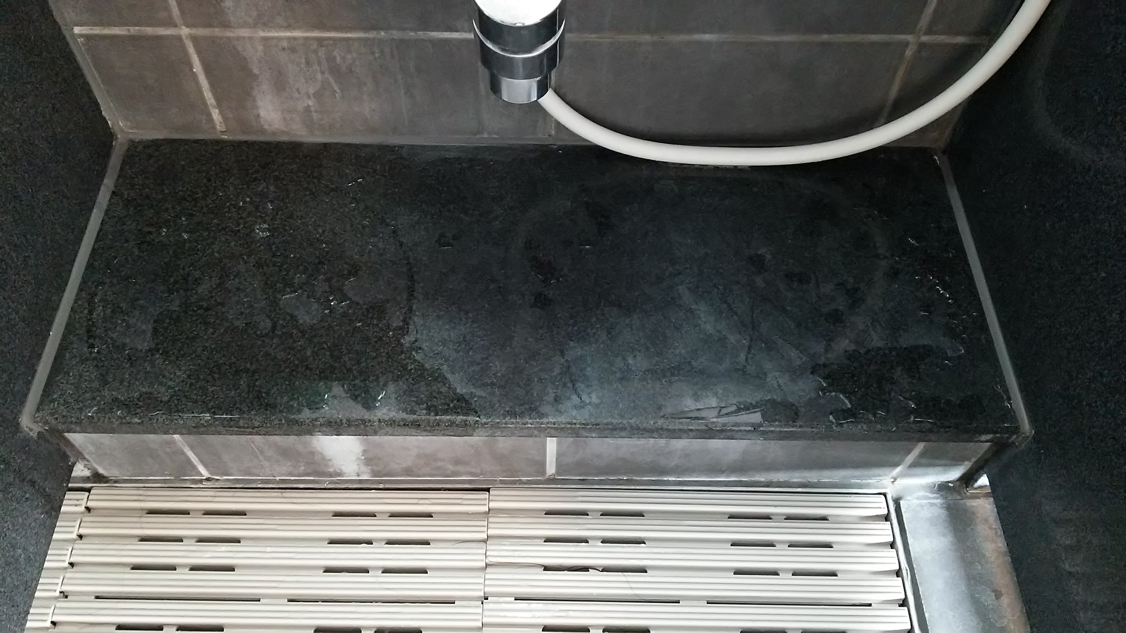ホテル・旅館の大浴場洗い場の黒御影石鏡面再研磨再生前